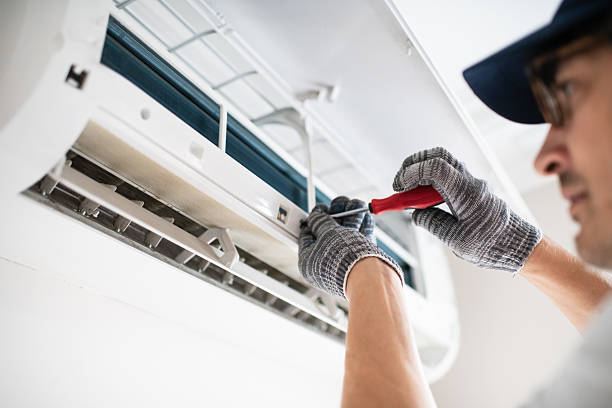 Technician evaluating residential HVAC equipment during a system service visit